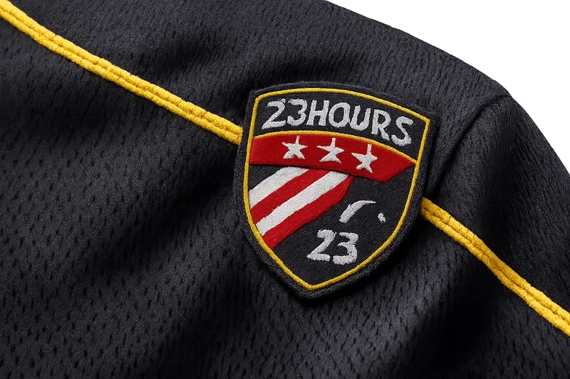 Close-up of 23Hours jersey fabric texture and embroidered crest